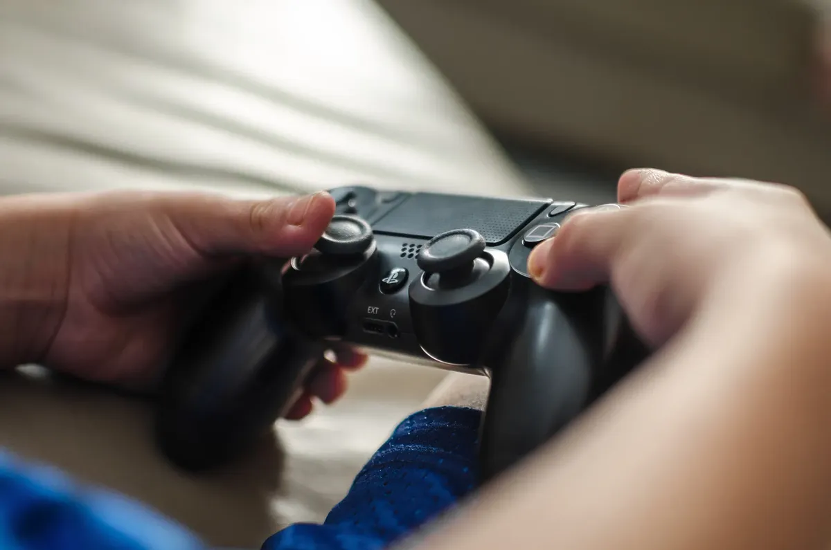 Close-up of hands holding a game controller, ideal for gaming and technology themes.