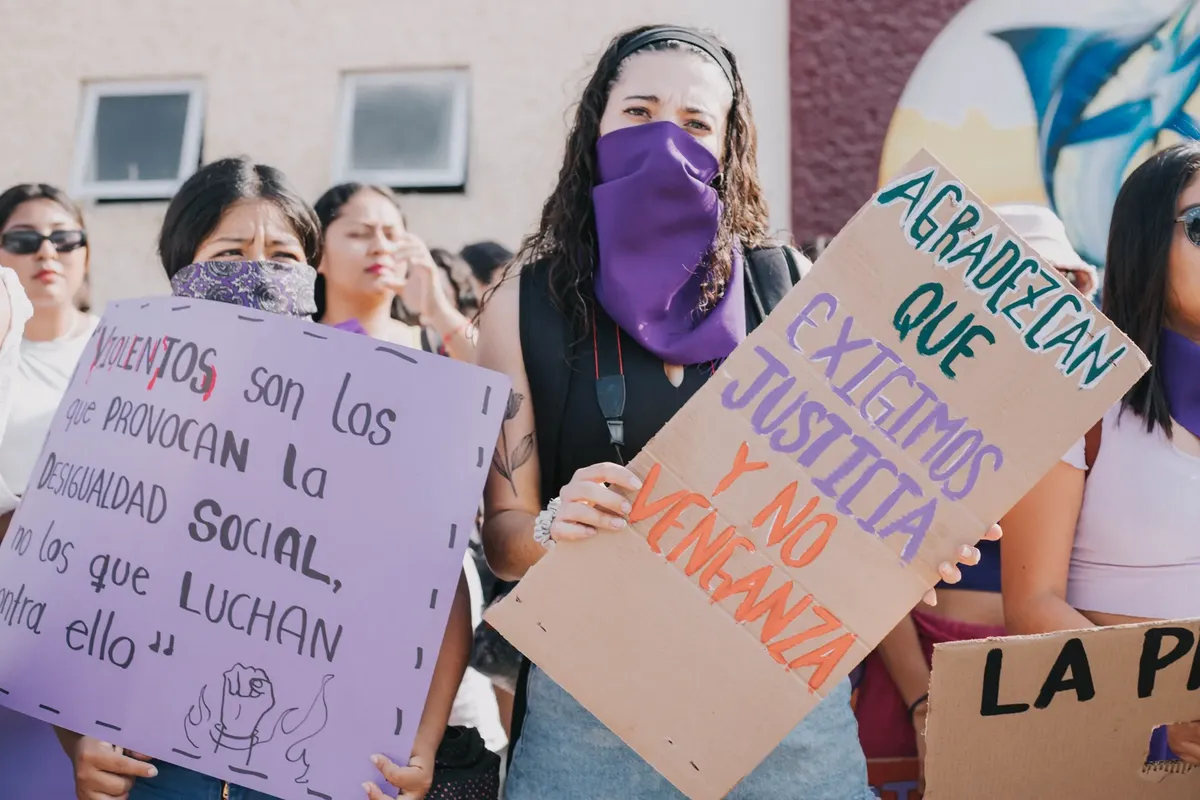 A group of women at a protest holding signs advocating for social equality and justice.