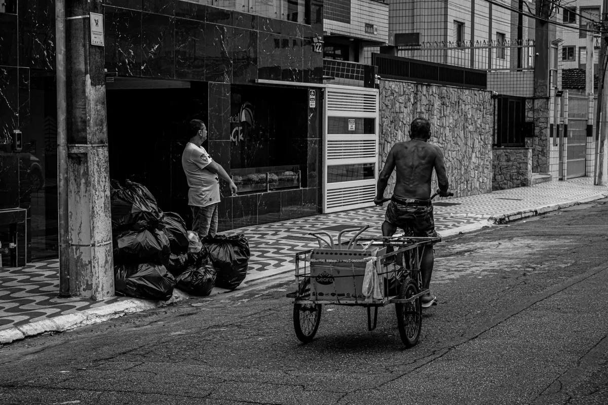 Black and white photo capturing daily life on the streets of Praia Grande, São Paulo, Brazil.