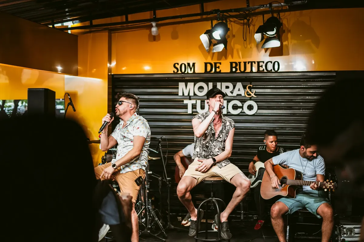 Vibrant live music performance featuring singers and guitarists in a bar.